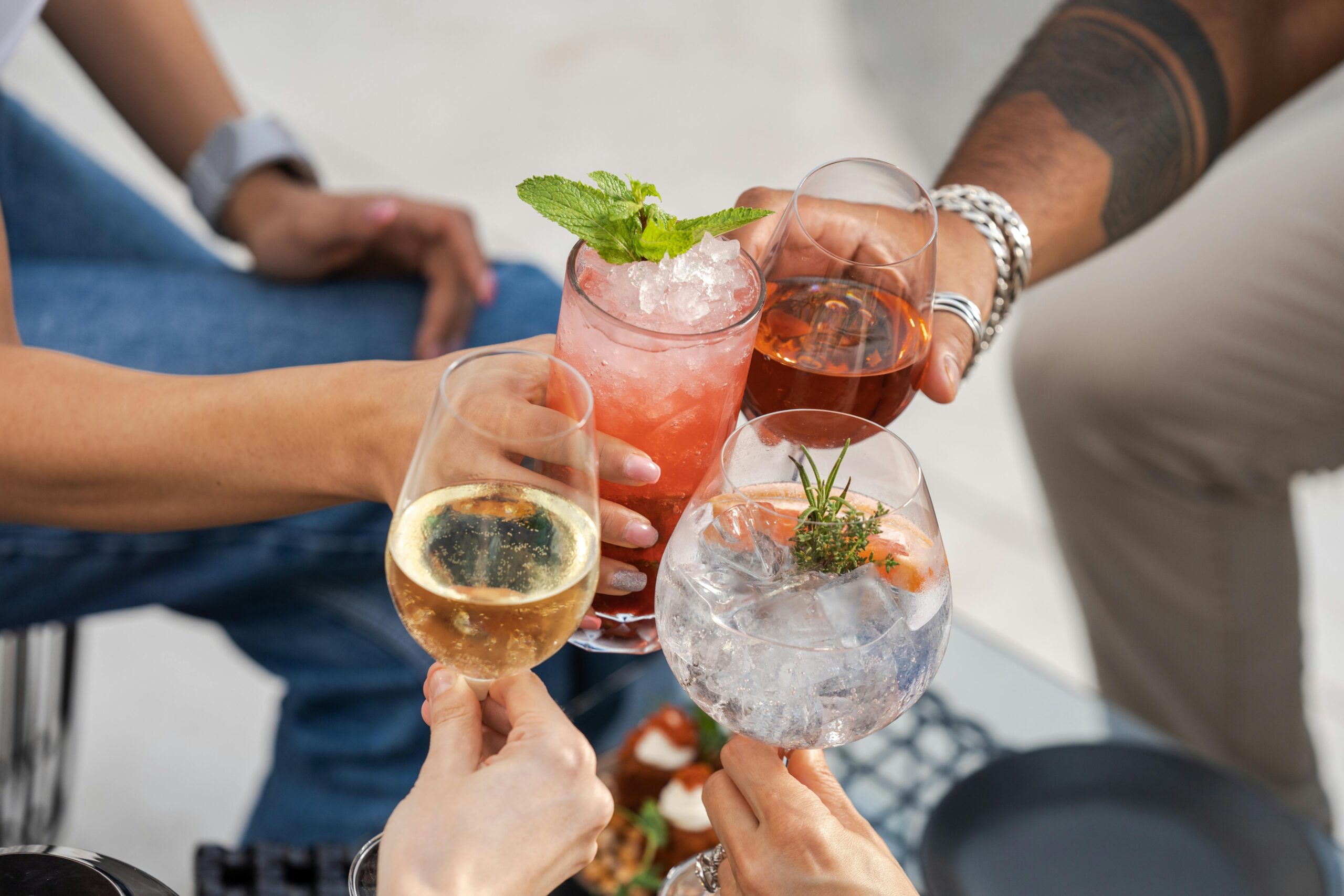 A joyful toast among friends with diverse cocktails, capturing a moment of celebration and camaraderie outdoors.
